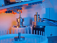 Close-up of a Satisloh SPM-10 grinding machine processing micro-optics.