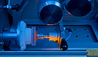Close-up of a machine precisely processing a glass lens during the manufacturing process