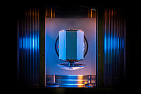 Front view of laboratory testing machine with a conical tool pressing a cylindrical sample