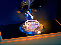 Precision machine automatically applying liquid or coating onto a glass lens