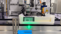 Automated laboratory station with robotic tools processing a sample container labeled with a barcode.