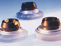 Three precisely manufactured glass lenses with metallic housings on a bright surface