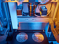 Automated machine processing two glass lenses simultaneously during the manufacturing process