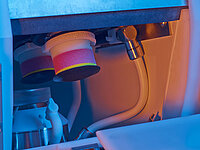 Close-up of polishing tools inside an industrial machine used for lens processing.