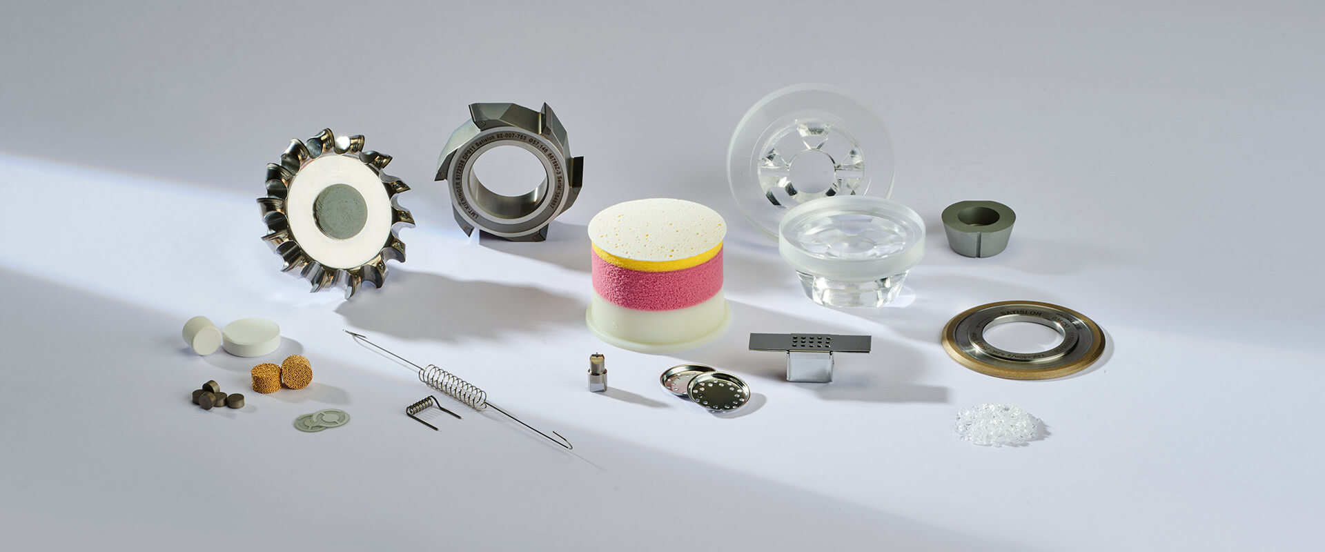 Assorted industrial machine components and tools arranged on a light surface
