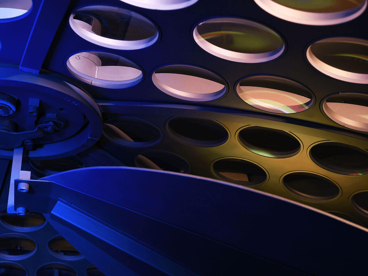 Close-up of an industrial machine with multiple circular lens holders.